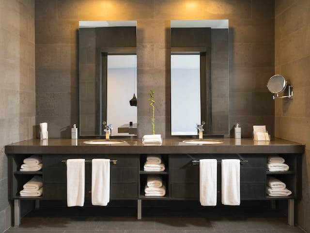 Empresa de Desentupir Esgoto proporcionando um banheiro limpo e toalhas brancas e espelhos brilhando.